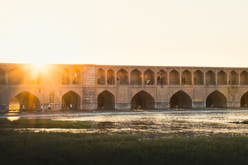 Isfahan, Iran - May 2022: people chill and socialize around SioSe Pol or Bridge of 33 arches, one...