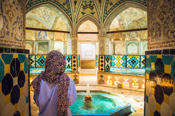 Kashan, Iran - 29th june, 2022: Tourist pose with Interior and art in hot bathing hall (garmkhaneh)...