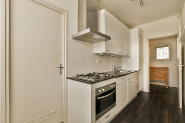 a kitchen with white cupboards and black counter tops on the floor in front of the door to the room