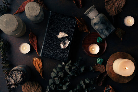 Witchcraft still life concept with potion, spell book, herbs ingredients candles and magical equipment