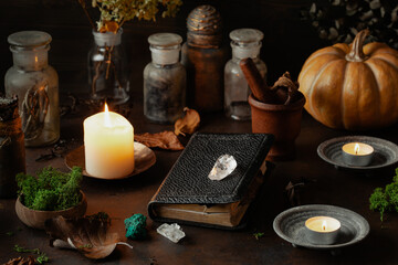 Fototapeta na wymiar Witchcraft still life concept with potion, spell book, herbs ingredients candles and magical equipment