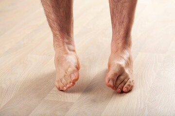 man doing flatfoot correction gymnastic exercise at home