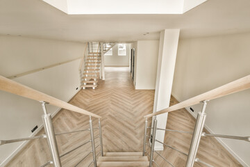 an empty room with stairs and staircases in the middle part of the room, taken from the top floor