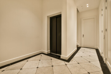 an empty room with white walls and black trim on the door, in front of it is a tiled floor