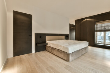 a modern bedroom with wood flooring and white walls in the room is well lit by the light coming through the window