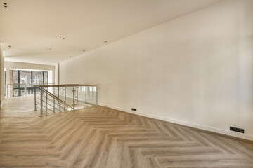 an empty room with wood flooring and white walls in the background is a staircase leading up to a glass door