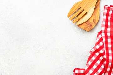 Wooden utensils and tablecloth on white kitchen table. Food background with copy space.