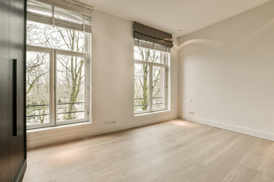 an empty room with wood flooring and large windows looking out onto the trees in the photo is taken from inside