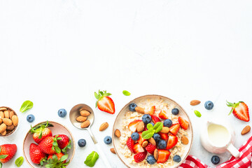 Oatmeal porrige with fresh berries and nuts. Healthy breakfast, top view.