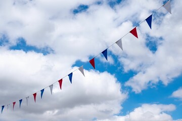 Low angle shot of small colorful paper flags on a string under a cloudy sky