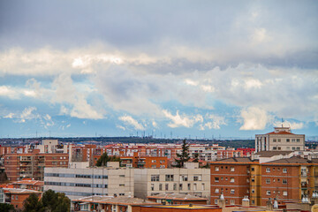 Obraz premium Skyline of the city of Madrid with cloudy sky and sierra mountains in the background