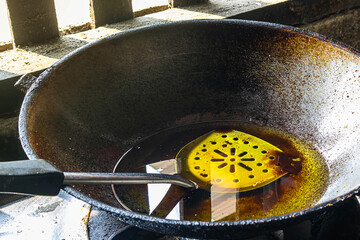 Used vegetable oil or cooking oil in a pan on a gas stove.