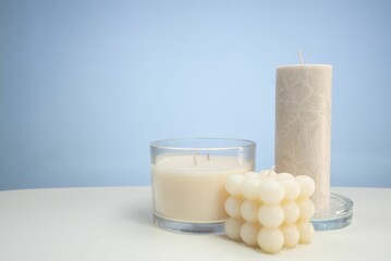 Closeup of three candles on a white surface with space for text