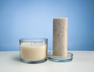 Closeup of two candles on a white surface with space for text