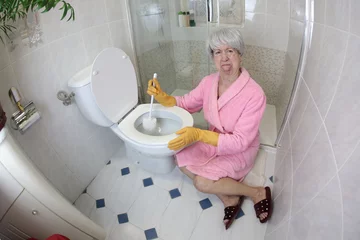 Foto op Canvas Grossed out senior woman cleaning the toilet  © ajr_images