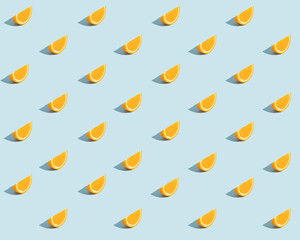 Stylish summer sun pattern made of orange slice on light blue background. Minimal summer concept.