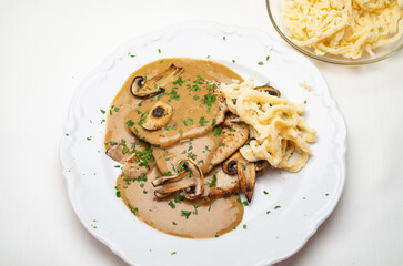 Schnitzel Champignon Sauce Spätzle auf Teller 