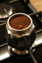 Fresh ground coffee on a moka pot on the stove