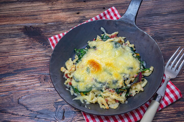 schwarze pfanne mit käse überbacken von oben fotografiert