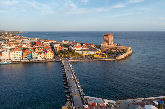 Aerial view of the queen emma bridge with the dutch architecture buildings in the background at sunset in Willemstad. Cura&ccedil;ao.