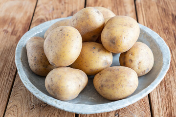 Fototapeta na wymiar Rohe Kartoffeln mit Schale in einem Teller 