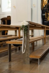 Beautiful, serene chapel interior featuring rows of wooden pews adorned with floral arrangement