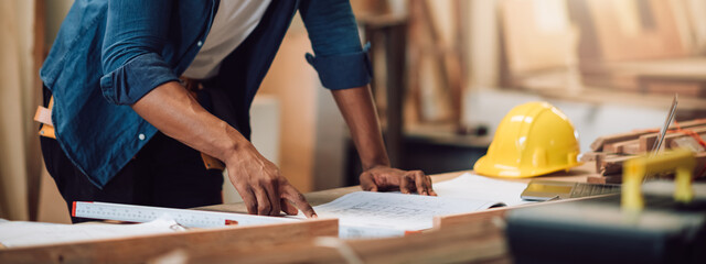 African american carpenter man working in wood factory, small business wood workshop. Timber industry and furniture factory.