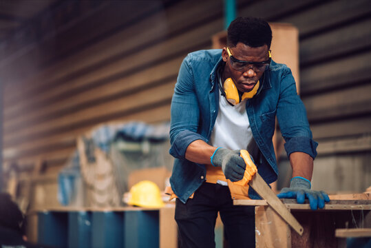 African american carpenter man working in wood factory, small business wood workshop. Timber industry and furniture factory.