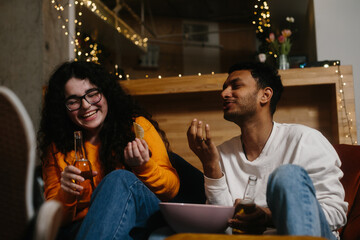 A company of friends in the evening in a cafe spend time together watching their favorite TV series.