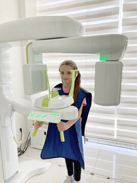 dentistry and healthcare: x-ray machine scanning kid patient teeth at dental clinic