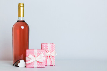 Bottle of wine on colored background for Valentine Day with gift box. Heart shaped with presrnt box perspective view with copy space