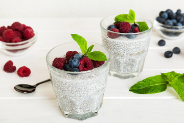 Healthy breakfast or morning with chia seeds vanilla pudding raspberry and blueberry berries on table background, vegetarian food, diet and health concept. Chia pudding with raspberry and blueberry