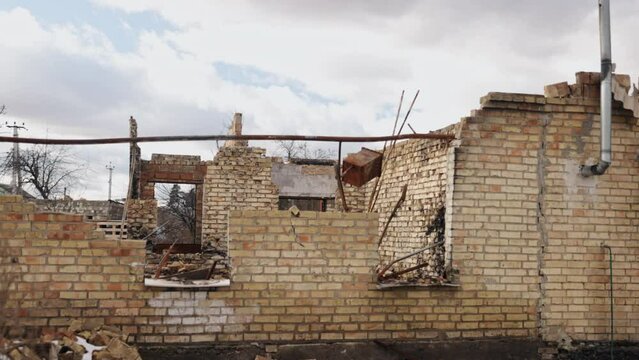 Terrible footage, uins of house, destroyed by war. Collapsed building in midst of disaster and there is flood of debris, dust and damaged house. Aftermath of bombing in Ukraine.