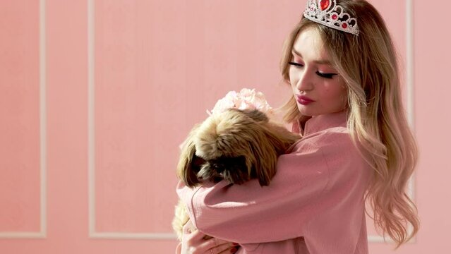 Made-up lady in pink shirt and crown holds dog shih tzu and flowers. Young woman and dog pose against wall with pink wallpaper in sunny room Generative AI