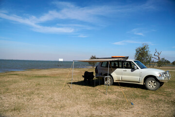 The camping setup using the Side awning with a table and chair near a lake © P.j.Hickox