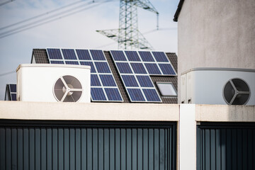 Wärmepumpe auf einem Garagendach eines Neubaugebiets, im Hintergrund sind Solarpanele auf Hausdächern montiert, Monheim am Rhein, NRW, Deutschland - obrazy, fototapety, plakaty