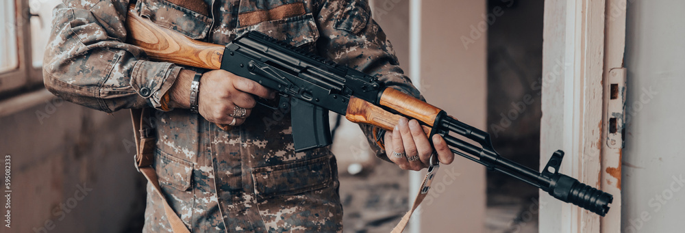 Wall mural Soldiers in camouflage with a military weapon