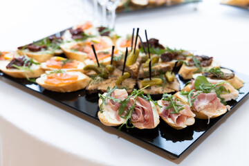 Jamon sandwiches on a tray with other food background is blurred