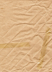 Fototapeta na wymiar Beige wrapping paper with diagonal folds, chaotic wrinkles, adhesive tape