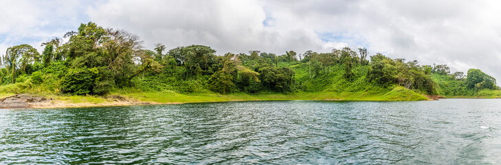 A view of the verdant shoreline of the Arenal Lake in Costa Rica during the dry season