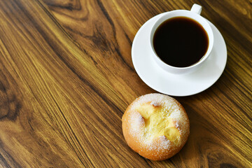 Pan dulce y taza de café sobre una mesa de madera. Hecho de yema de Huevo y harina de trigo. Postre tradicional de Guatemala.