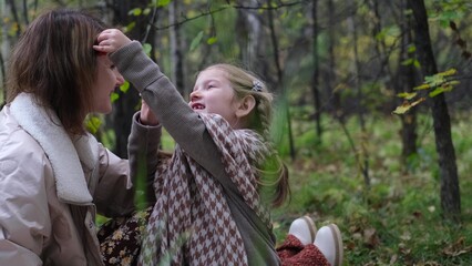 Hello September. A young mother and little daughter walk in the city park in autumn.