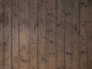 Weathered wooden flooring in a house. Wood grain of dark timber planks as abstract background. Empty space of a surface with brown boards.