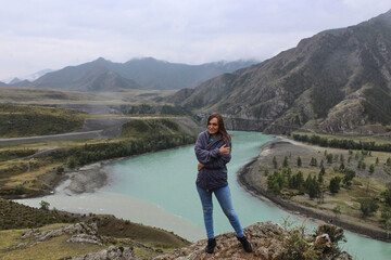 The confluence of two rivers of different colors Chuya and Katun into one. Mountain landscape, young women