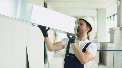 Funny hvac worker screams in a ventilation pipe. Advertising. Man screaming announcement in a ventilation pipe on construction site