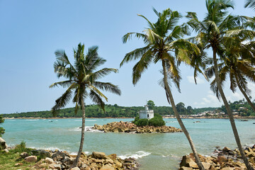 An old weathered lighthouse on a small island off the rocky shores of Dixcove, Ahanta West District, Ghana