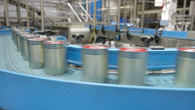 Sealed food cans on a conveyor belt in a food production facility