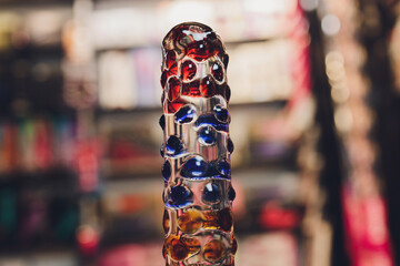 Anal glass butt plug with a fluffy tail with female hands. Toy for adult games.