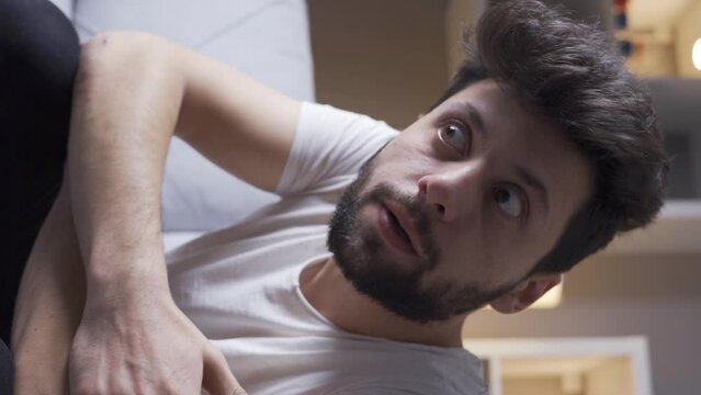 Vertical Video of Schizophrenic man going crazy at home.
Mentally ill schizophrenic man staring blankly, hallucinations.
