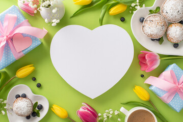 Show your love on Mother's Day with a beautiful top view flat lay of cupcakes, presents, coffee cup, and tulips on a pastel green background with an empty heart for your message or text